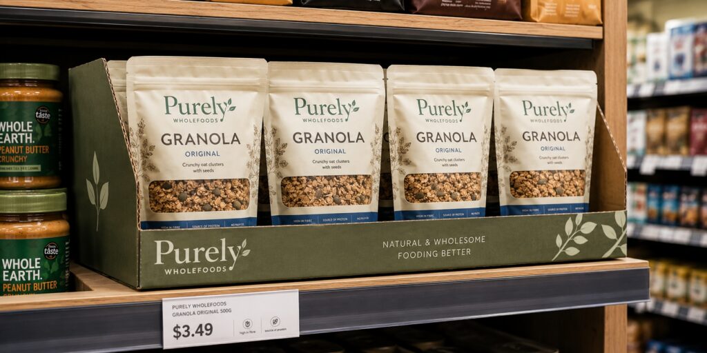 shelf-ready corrugated tray with consumer units on retail gondola — retail-ready secondary packaging in place